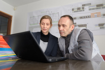 workers looking at a laptop in an office