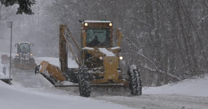 Plows clear a snow covered road after a heavy winter blizzard