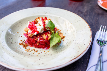 The dessert of wild strawberries with whipped cream is on the plate