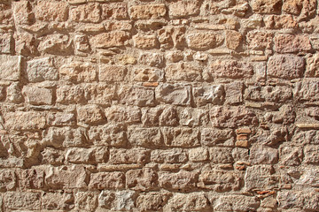 medieval stone wall of old building in sunny day