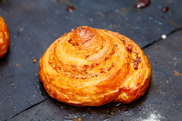 Pastry chef pouring melted chocolate, the round roll of puff pastry.