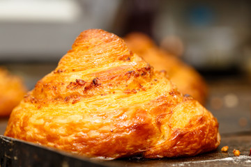 Pastry chef pouring melted chocolate, the round roll of puff pastry.