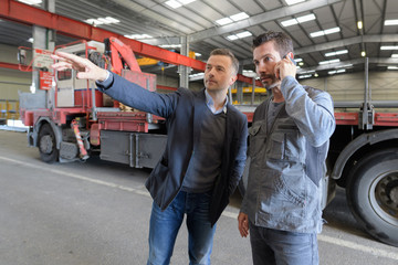 mid adult businessman with supervisor having discussion in metal industry