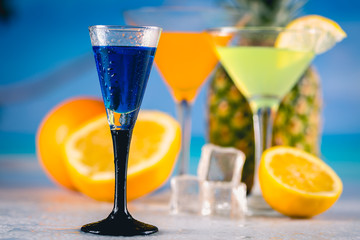 Blue exotic drink on the beach with palms in background