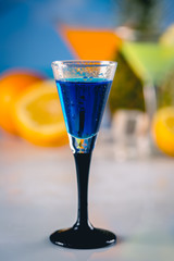 Blue exotic drink on the beach with palms in background