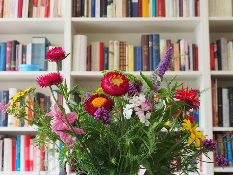 Interieur: Feldblumenstrauss vor B&uuml;cherwand