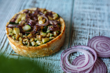 Australian meat  pie on the table and avocado, chilli, chips, rustic style. Homemade meat pie on the wooden table. Delicious cut meat pie on a plate. American Chicken pot pie