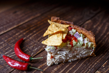 Australian meat  pie on the table and avocado, chilli, chips, rustic style. Homemade meat pie on the wooden table. Delicious cut meat pie on a plate. American Chicken pot pie