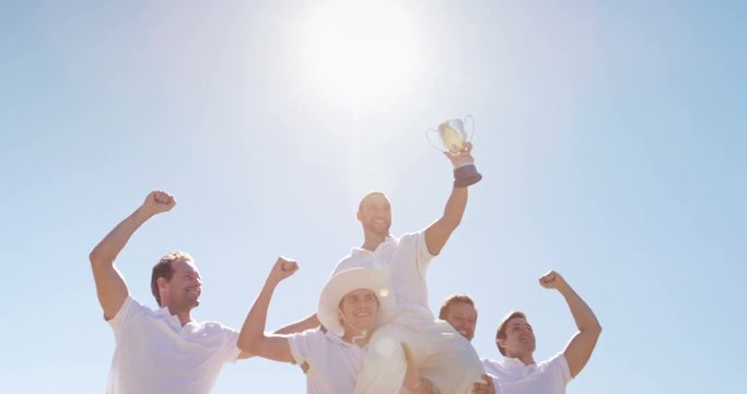 Cricket team with trophy on cricket field