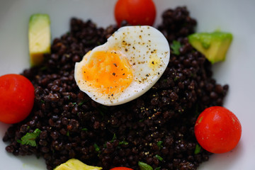 Beluga lentil salad with a soft boiled egg on top