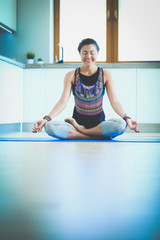 Young woman doing yoga at home in the lotus position. Yoga. Woman. Lifestyle