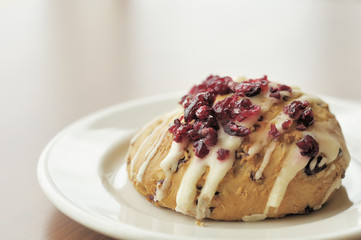 Cranberry scone topped with cranberry pieces and icing