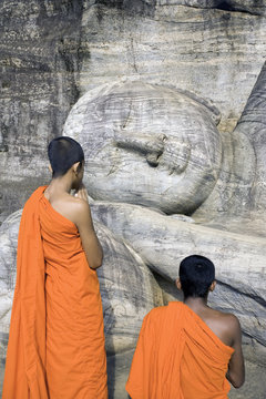 Monks praying at a rock-cut image of the Buddha in the Gal Vihara, Polonnaruwa (Polonnaruva), UNESCO World Heritage Site, Sri Lanka, Asia