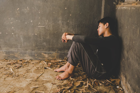 Scared Or Terrified Boy Sitting At Wall. Aggressive Parent And Frightened Child In Corner. Domestic Family Violence And Aggression Concept Violence.