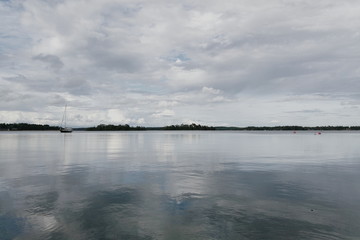 Solitaire boat on calm sea and cloudy sky 