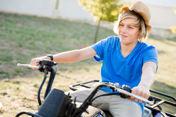 Obraz premium Boy riding farm truck in vineyard