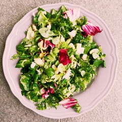 Green salad vegan on white plate 