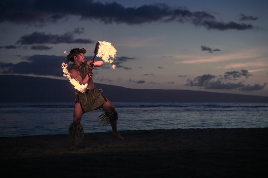 Traditional Hawaiian Fire Dancer twirling and tossing his flaming torch.
