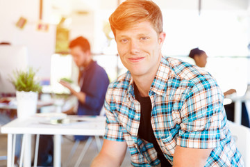 Young man sitting and looking at camera in office