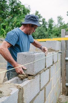 Builder working on a construction site building a wall