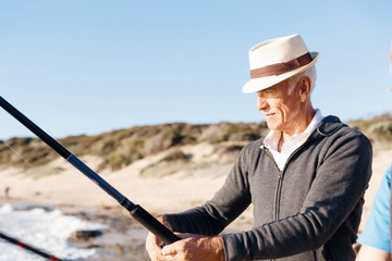 Senior man fishing at sea side