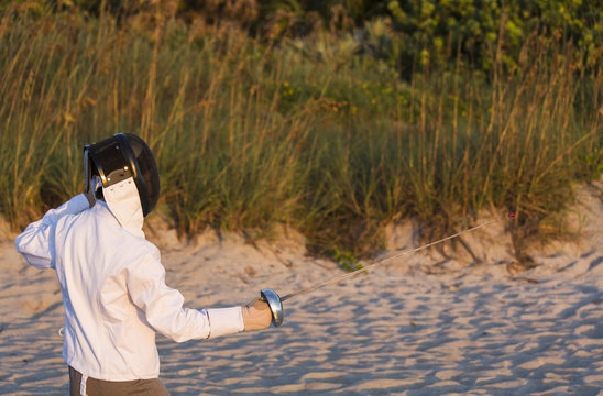 Fencer Practicing on the Beach at Sunrise