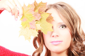 Fashion autumnal girl with maple leaves in hand