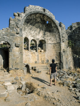 Man looking at a ruin of a church on Gemiler Island, Fethiye, Turkey