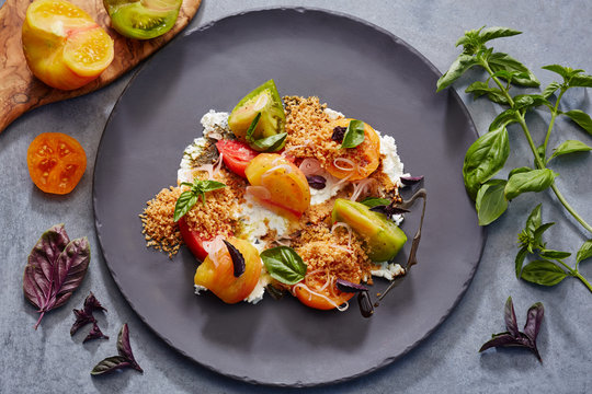 Heirloom tomato salad with burrata cheese, sweet basil saba and pine nut gremolata 