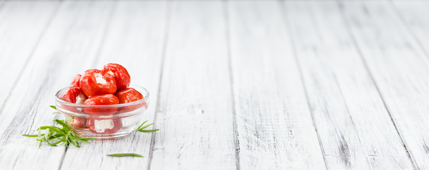Portion of Red Pepper (stuffed with cheese) on wooden background (selective focus)
