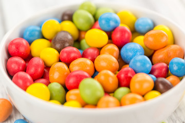 Portion of Cocolate coated Peanuts on wooden background (selective focus)