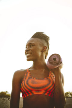 Woman Stands with Yoga Mat