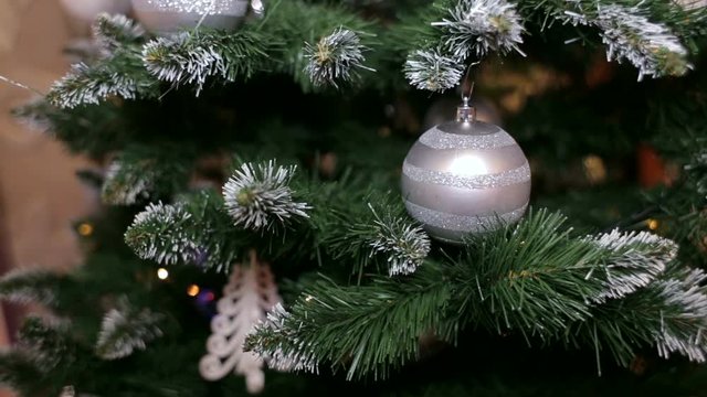 Silver christmas balls on a christmas tree. New year's balls on branch spruce on blur background.