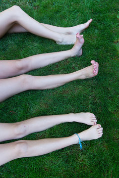 vertical shot of legs and feet of three tweens