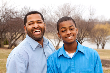 Happy African American father and son talking and laughing.