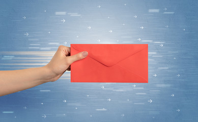 Hand holding envelope with arrows around