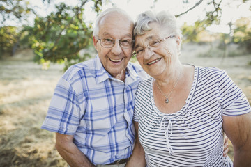 Cute elderly couple smiling together outside