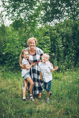 Fototapeta premium Grandmother playing in the park with grandchildren