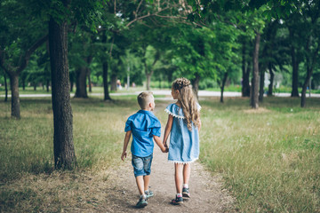 Obraz premium A little boy and girl walking together and holding each other hands
