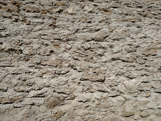A solid wall with a stone on a summer day .