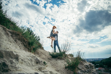 Obraz premium young man hold woman on the peak