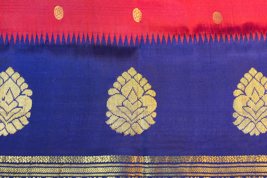 Indian red silk sari with blue border and gold floral design.