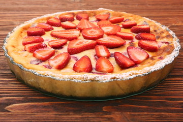 Tart with fresh strawberry on wooden background