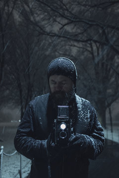 man photographing with a dual lens reflex camera in the snow