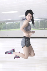 Slim woman leaping at gym center