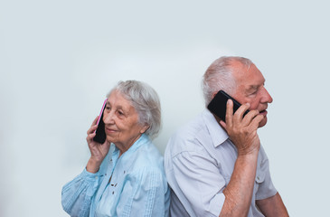 Senior couple at home using smartphones