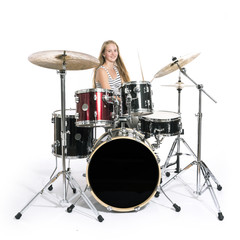 Fototapeta na wymiar young blond teenage girl plays the drums in studio against white background