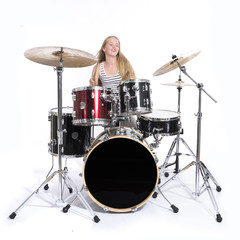 Fototapeta na wymiar young blond teenage girl plays the drums in studio against white background
