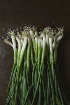 Overhead view of spring onions on wooden table