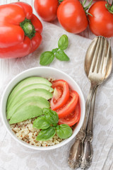 Warm quinoa salad with vegetables - avocado, red onion, tomatoes, bell pepper, Basil and olive oil. Healthy grain, super-duper. Selective focus